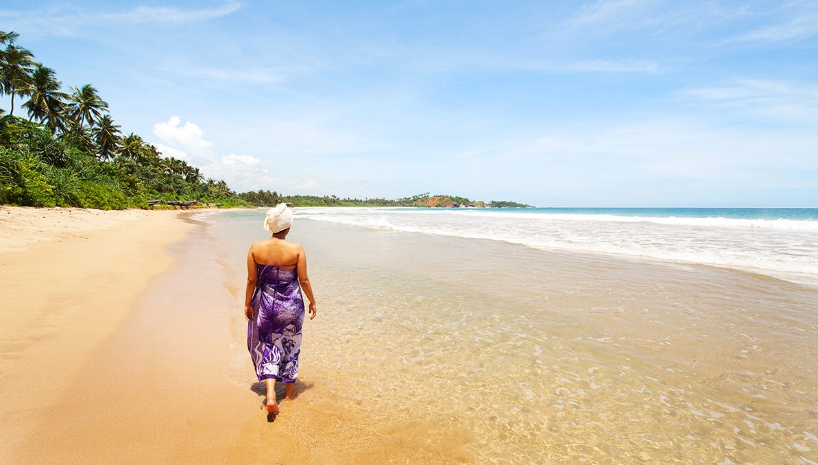 Frau zu Fuß am Strand nach Ayurveda kur in Sri Lanka